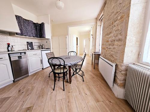 une cuisine avec une table et des chaises dans une pièce dans l'établissement Les Reflets, à Chalon-sur-Saône