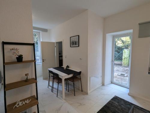 ein Esszimmer mit einem Tisch und einem Fenster in der Unterkunft Nord-Apartment 5 I 1 Zimmer mit einladendem Wohnbereich im Erdgeschoss in Bremerhaven