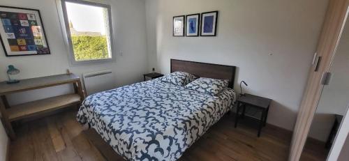 une chambre avec un lit avec une couette bleue et blanche dans l'établissement Agréable maison familiale, à Carcans