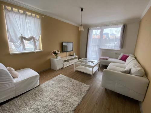 a living room with two white couches and a tv at BAGRA Apartment, 1-4 guests, Free Parking & Wifi, 10 min from Downtown in Dúbravka