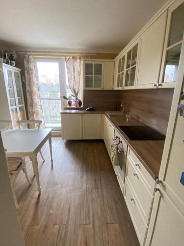 a kitchen with white cabinets and a table and a window at BAGRA Apartment, 1-4 guests, Free Parking & Wifi, 10 min from Downtown in Dúbravka