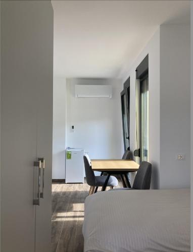 a room with a table and chairs and a bed at Hadri-rooms in Korçë
