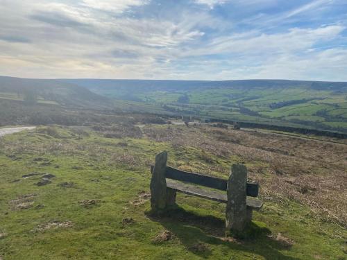a bench on top of a hill with a view at NY Moors' peaceful retreat - Great Fryup, Lealholm in Fryup