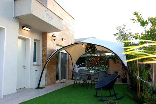 a patio with a table and chairs under an archway at עידן יחידת נופש אילת in Eilat