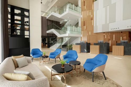 eine Lobby mit einem Sofa und blauen Stühlen in der Unterkunft Courtyard by Marriott Dakar Diamniadio in Dakar