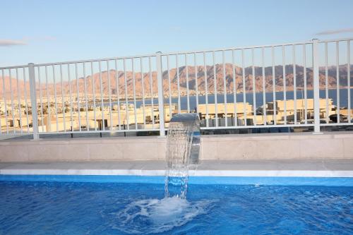 a fountain in the middle of a swimming pool at עידן יחידת נופש אילת in Eilat