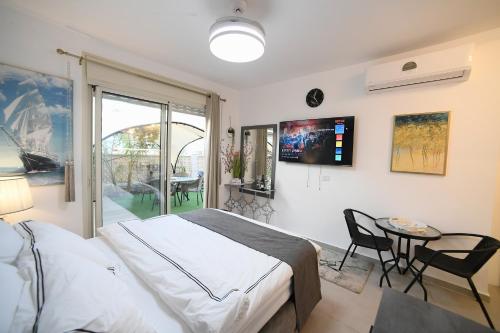 a bedroom with a bed and a table and a window at עידן יחידת נופש אילת in Eilat