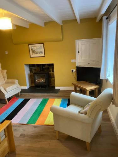 a living room with a couch and a fireplace at NY Moors' peaceful retreat - Great Fryup, Lealholm in Fryup