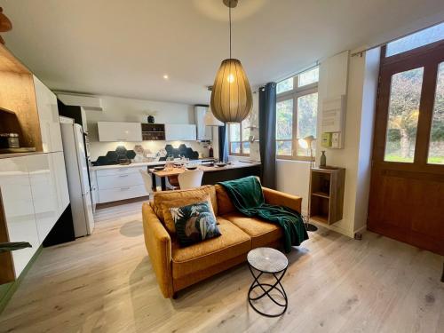 un salon avec un canapé et une cuisine dans l'établissement Le coin de Mel, Parking privé, 6 personnes, à Saint-Alban-de-Roche