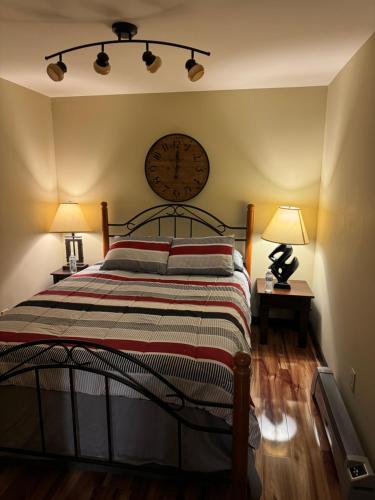 a bedroom with a bed with a clock on the wall at Spacious St Croix River Home with Private Beach in Lakeland