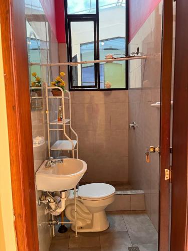 a bathroom with a toilet and a sink at La Casa Ambateña in Ambato