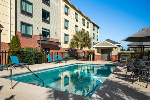 a swimming pool with chairs and a building at TownePlace Suites by Marriott Florence in Florence
