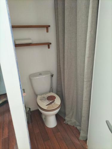 - une salle de bains avec des toilettes avec une étiquette sur le couvercle dans l'établissement Petite maison chaleureuse, à Landéhen