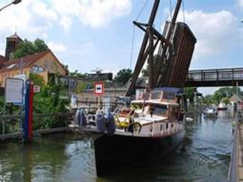 a boat is docked in the water under a bridge at Ferienhaus Zum Storchennest in Storkow in Storkow
