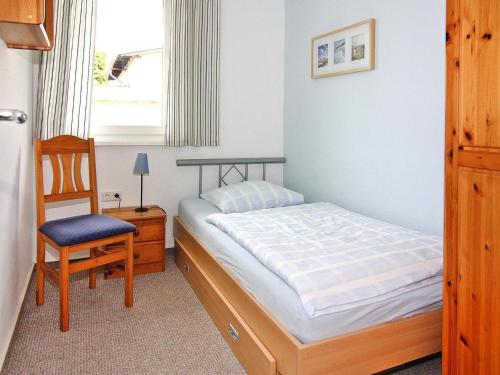 a bedroom with a bed and a chair and a window at Appartementhaus, Zinnowitz in Zinnowitz