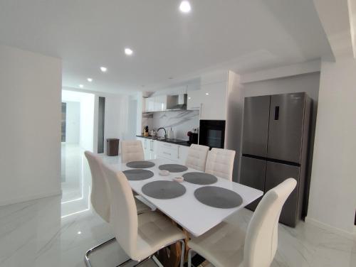 Una cocina con mesa y sillas y un refrigerador. en Mediterranean Stays Platinum, en Alicante