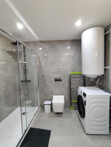 a bathroom with a shower toilet and a washing machine at Mediterranean Stays Platinum in Alicante