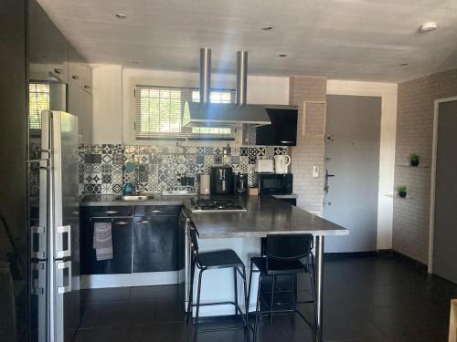 - une cuisine avec un comptoir et des chaises dans l'établissement Appartement cosy proche des plages et commodités, à Nice