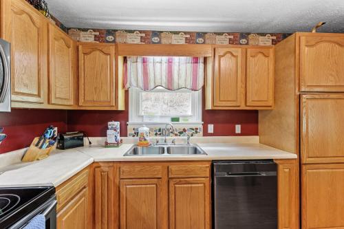 a kitchen with wooden cabinets and a sink and a window at Sundance Cabin in Stanton