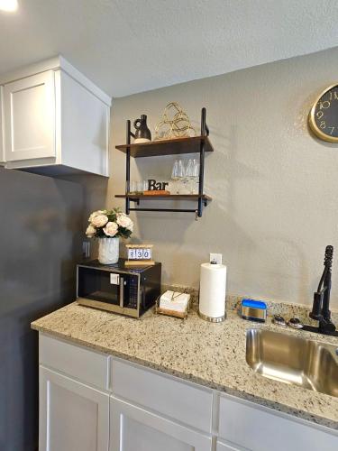a kitchen counter with a microwave and a sink at Belton Lakehouse in Belton