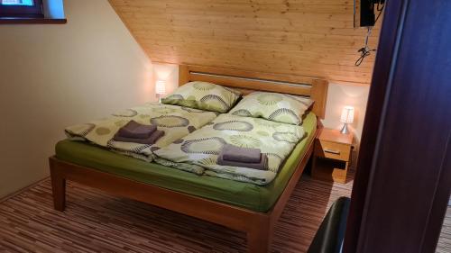 a bedroom with a bed with a wooden wall at Vinárstvo u Kohúta in Skalica