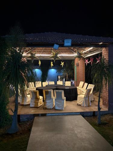 a patio with a table and chairs at night at Niladri farms in Bhundsi