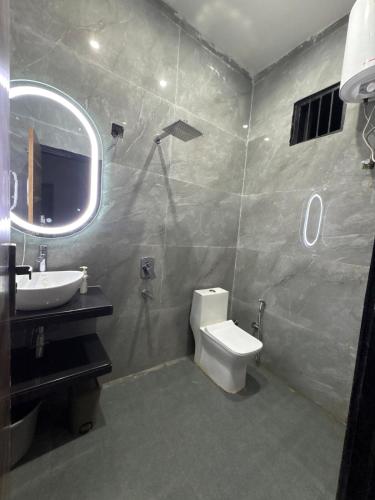 a bathroom with a toilet and a sink and a mirror at Niladri farms in Bhundsi
