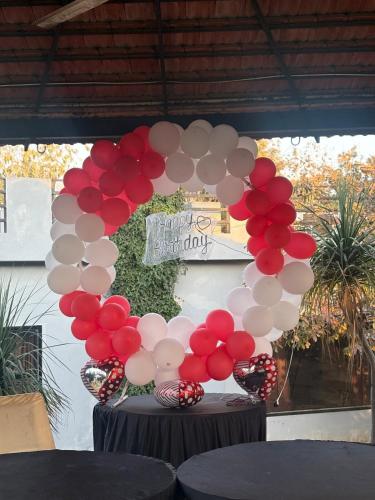 a bunch of red and white balloons on a table at Niladri farms in Bhundsi