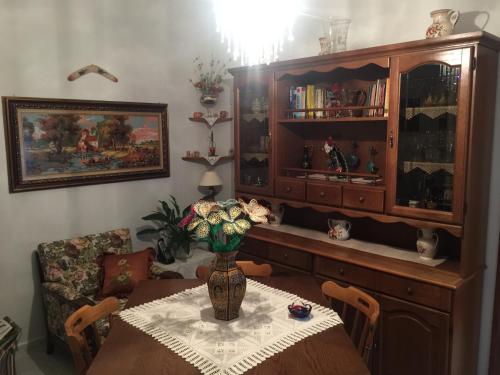 a dining room with a table with a vase on it at A casa di mamma in Rieti