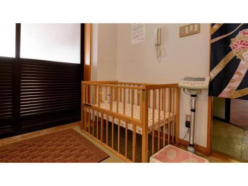 a crib in a room with a door and a sink at Kaifutei Teradomari Nihonkai - Vacation STAY 25854v in Nagaoka