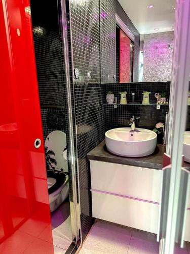 une salle de bain avec un lavabo et des toilettes dans l'établissement Cap Red Room, au Cap d'Agde