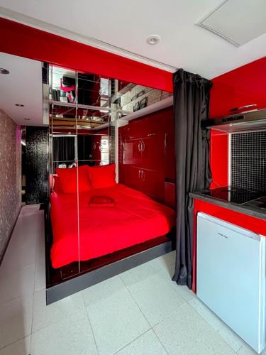 Cette chambre comprend un lit rouge. dans l'établissement Cap Red Room, au Cap d'Agde