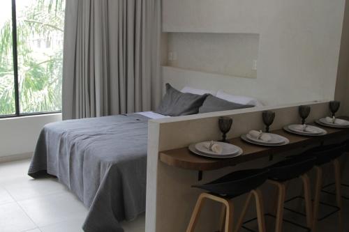 a bedroom with a bed and a table with plates on it at Minimalist Terracota Chapu in Guadalajara