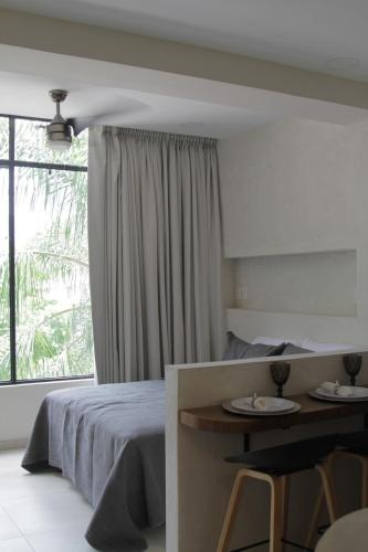 a bedroom with a bed and a table and a window at Minimalist Terracota Chapu in Guadalajara