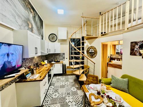 Il comprend une cuisine avec des placards blancs et une télévision murale. dans l'établissement Amber Apartment Nice - Central Highlights and Beach, à Nice