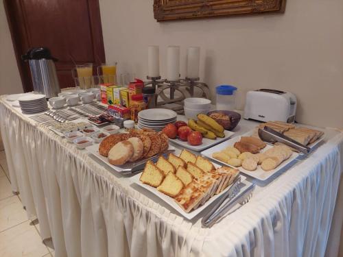 a table with many different types of bread and pastries at LA CASONA Hotel Boutique in Refineria Camiri
