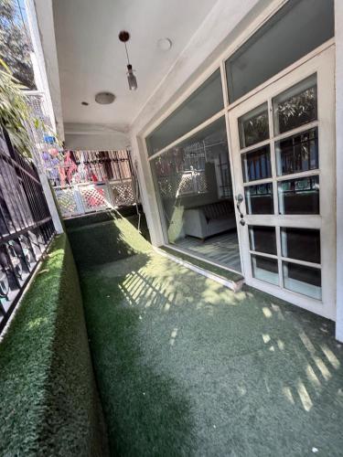 una casa con césped verde frente a un edificio en Woodbridge GK 1, en Nueva Delhi