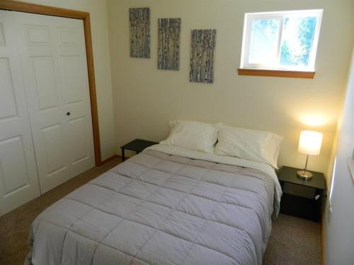 a bedroom with a white bed and a window at PA Whispering-Pines in Port Angeles