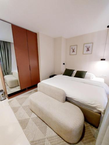 a bedroom with a large white bed and a chair at Peartree Homes in Lagos