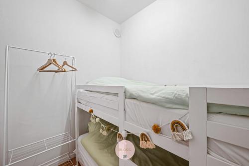 Casa Tropezina by BLOSS familieappartement met terras في أوستند: غرفة نوم عليها سرير وعليها حذاء