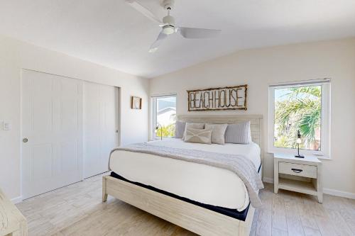 a white bedroom with a bed and a window at Lime in the Coconut in Marathon