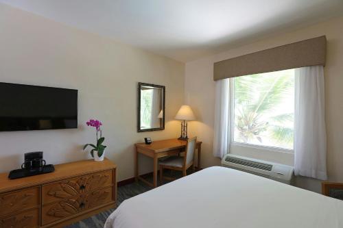 a bedroom with a bed and a television and a desk at Four Points by Sheraton Santo Domingo in Santo Domingo