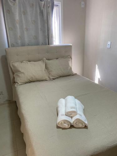 a bed with towels sitting on top of it at Pousada Le Sorelle ap04 in Rosário do Sul