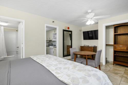 a bedroom with a bed and a table and a kitchen at The Fairways Inn of Naples in Naples
