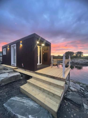 a small cabin on the water with a dock at Sjøberg Hotell og Ferie Leiligheter in Østhusvik