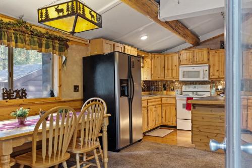 Una cocina con refrigerador de acero inoxidable y gabinetes de madera. en Hayloft Hollow, en Island Park