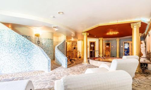 a lobby with white chairs and a staircase at Apartmán Stella, Vysoké Tatry in Tatranska Strba