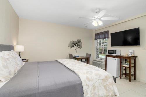 a bedroom with a bed and a flat screen tv at The Fairways Inn of Naples in Naples