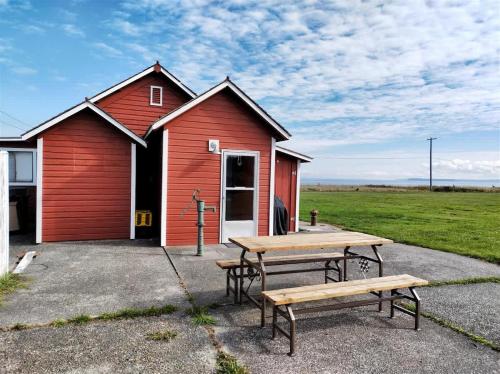 a red building with two picnic tables in front of it at SQ The-Crab-Shack in Sequim