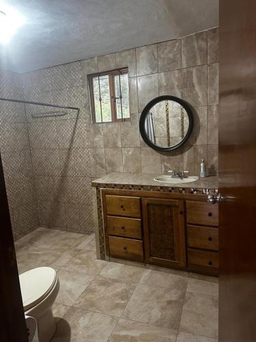 a bathroom with a toilet and a sink and a mirror at Cabaña Cedros Mineral del Chico in Mineral del Chico